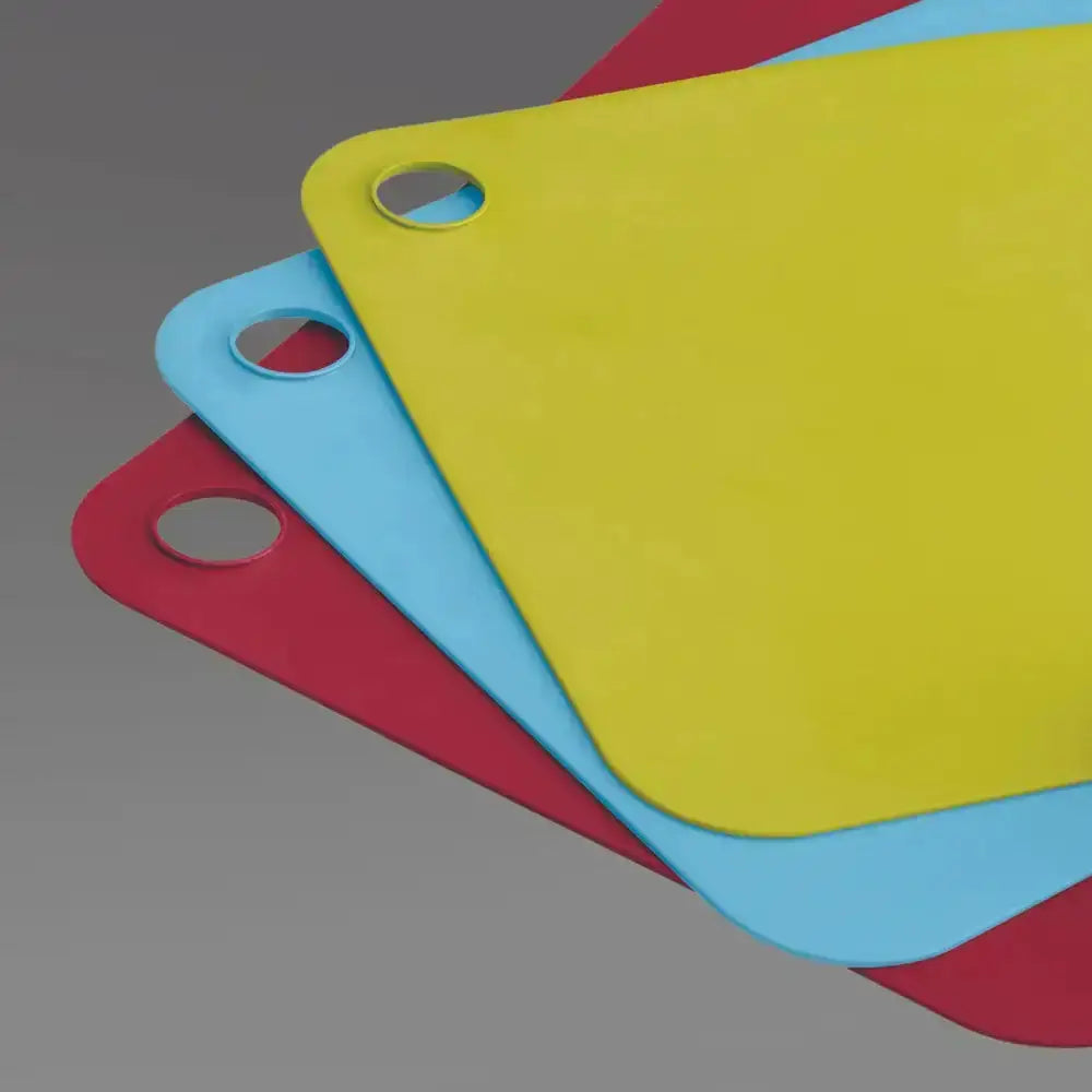 Three colorful cutting boards (yellow, blue, red) on a gray background