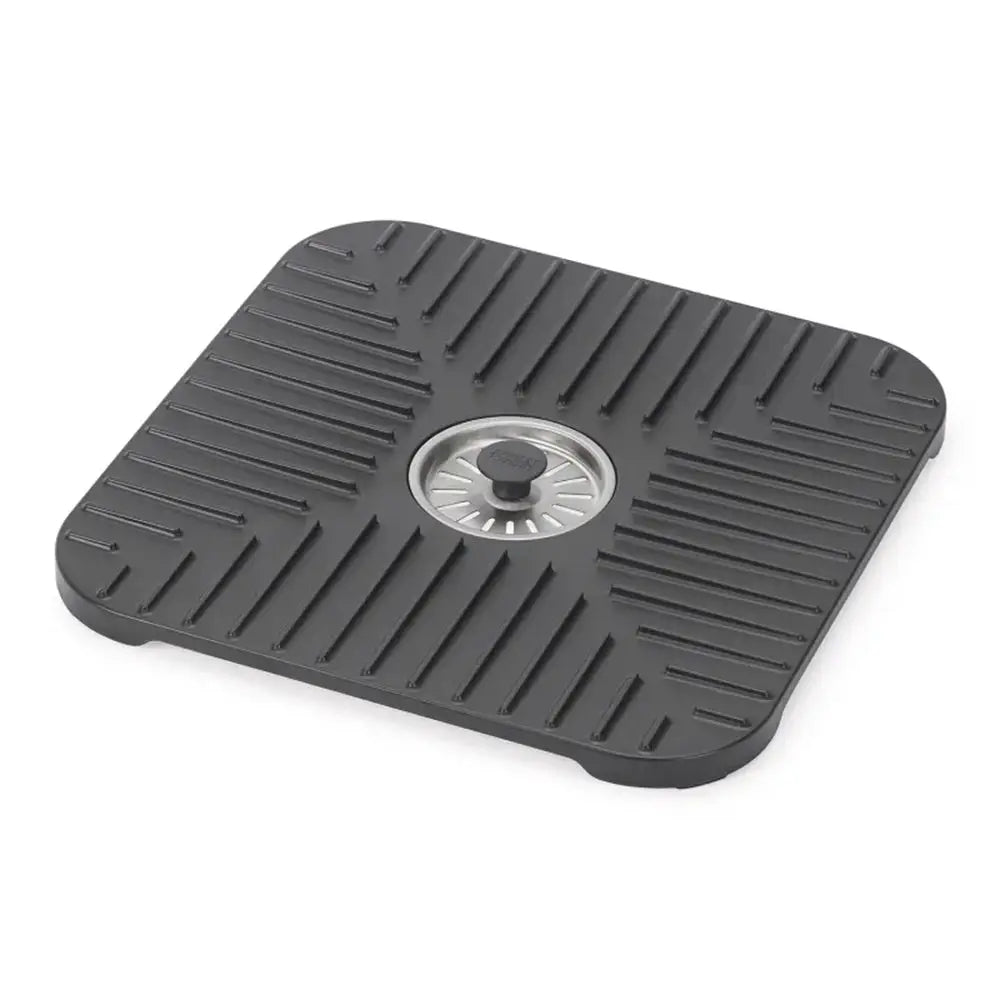 Black rubber mat with a central drain hole on a white background