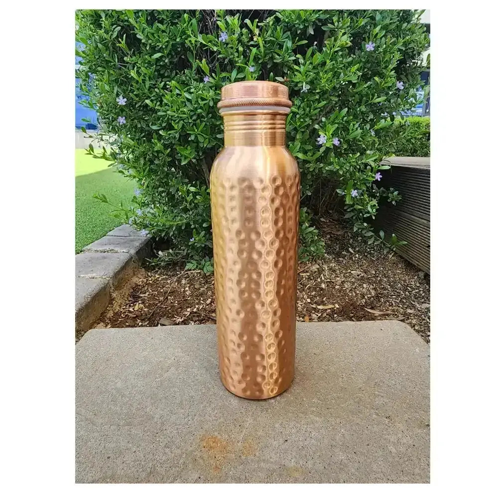 Dimpled copper water bottle with screw cap, outdoor setting, 900ml capacity