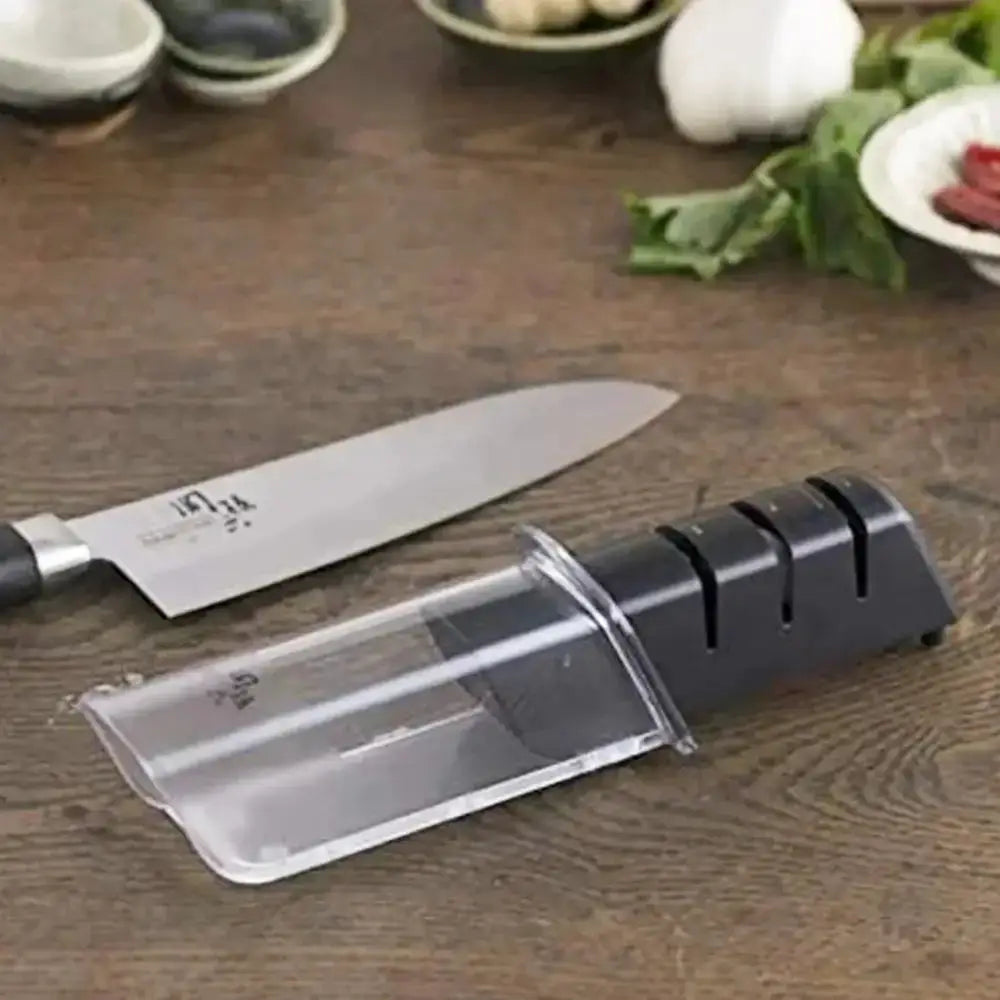 Knife sharpener on a wooden surface with a knife next to it