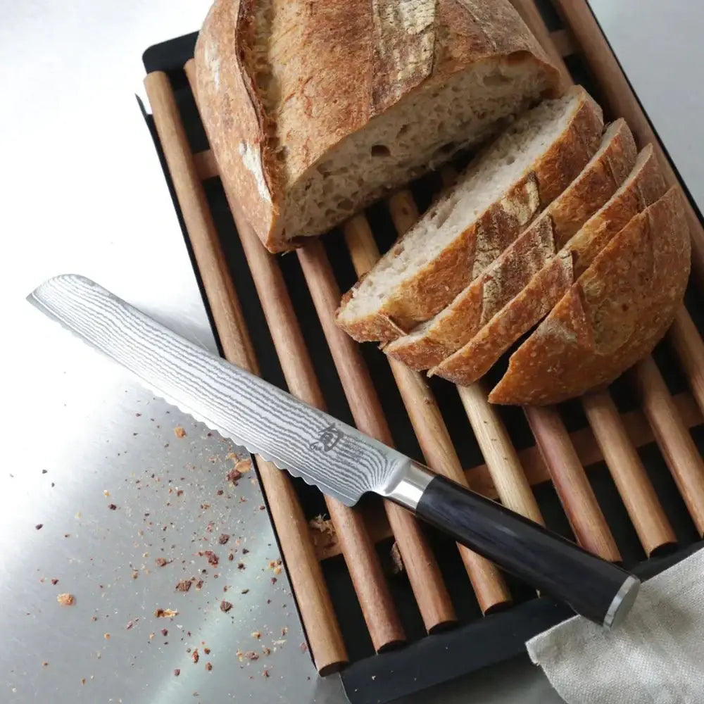 Sliced bread on a wooden cutting board with a knife next to it