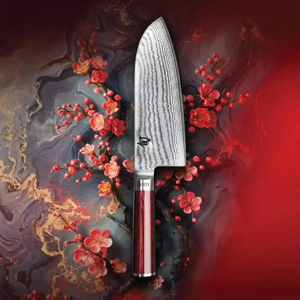 Chef's knife with a red handle on a dark, abstract background with flowers
