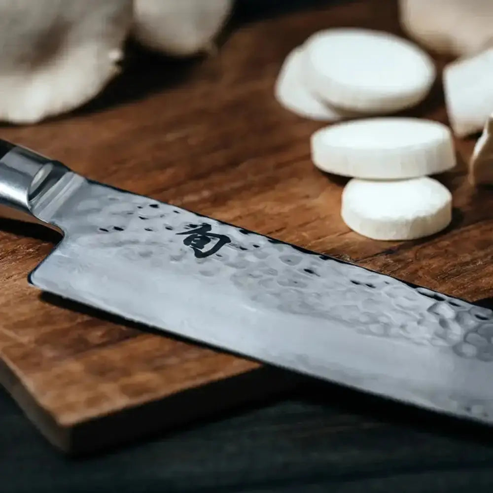 Chef's knife with a wooden handle on a cutting board with mushrooms