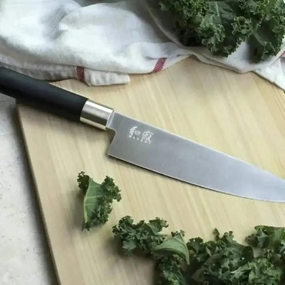 Knife on a wooden cutting board with kale leaves