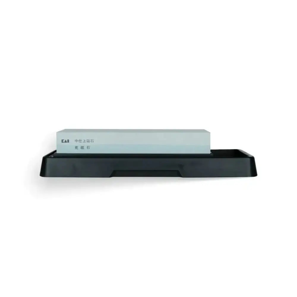 Rectangular black tray with a white stone on a white background