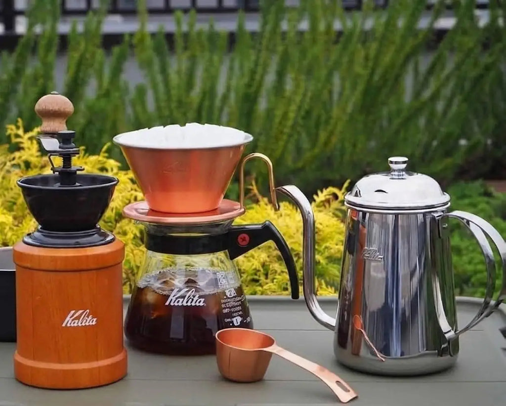 A sleek copper kalita pour-over dripper with white filter on a glass coffee server 500ml made of heat-resistant borosilicate glass