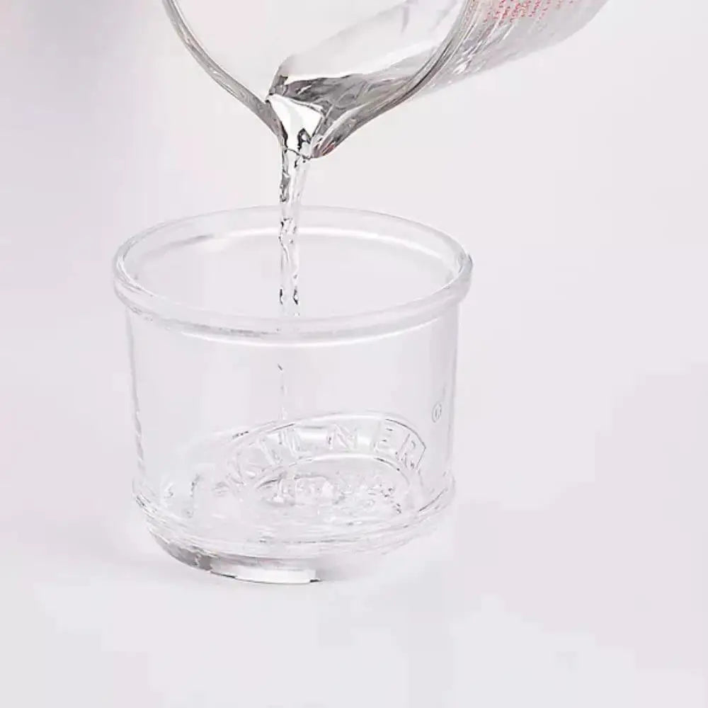 Clear glass container with a brand logo being filled with water on a white background