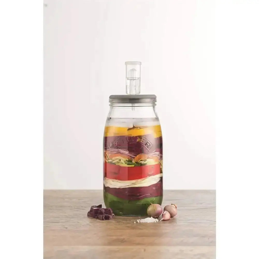 Glass bottle with layered ingredients on a wooden surface