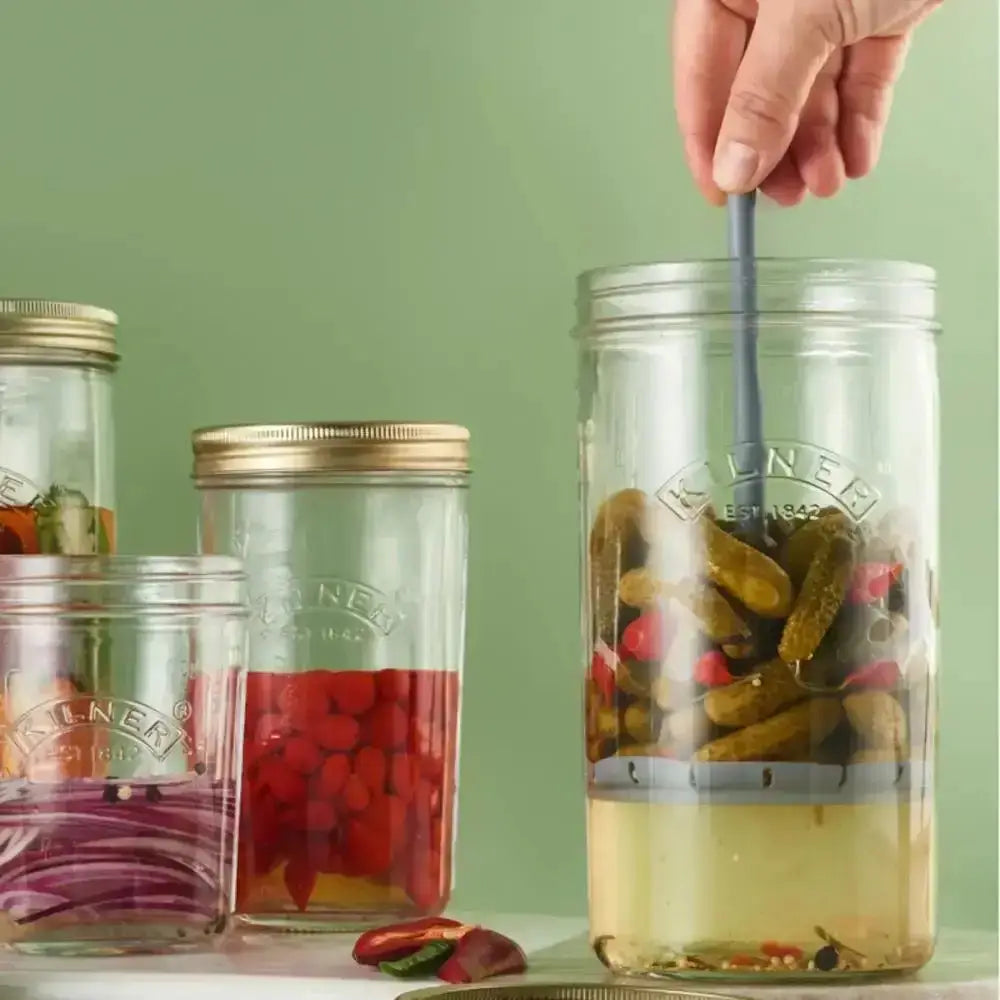Set of Ball brand canning jars with various contents on a green background