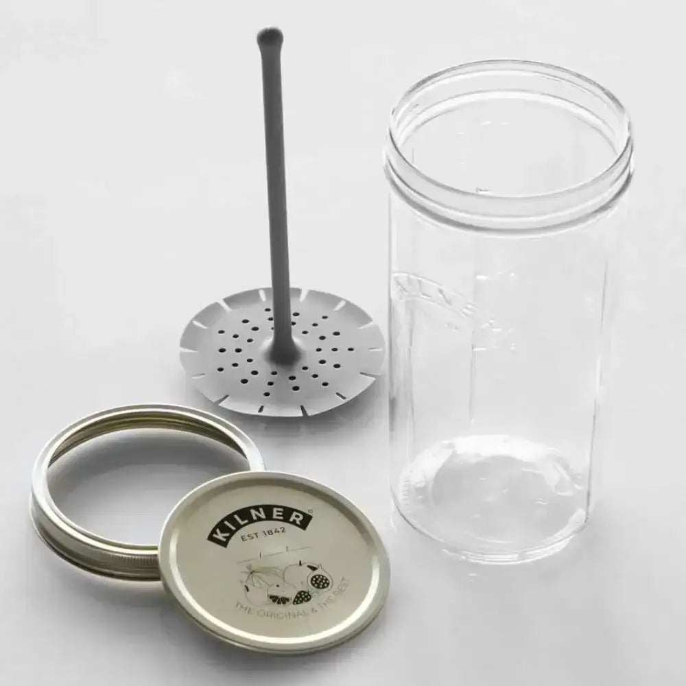 Clear glass jar with metal lid and strainer on a white background