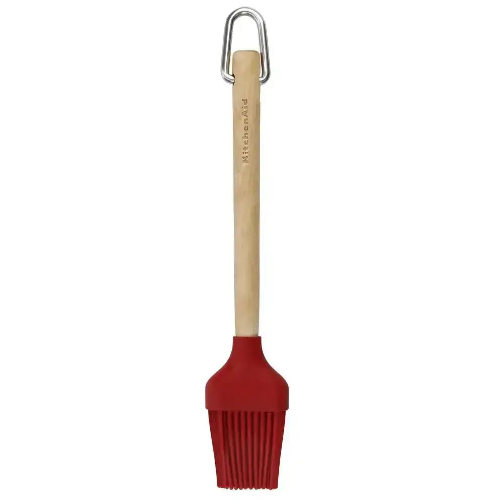 Red silicone brush with wooden handle on a white background
