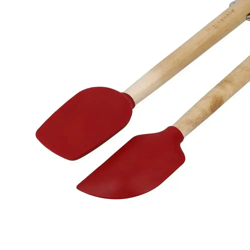 Two red silicone spatulas with wooden handles on a white background