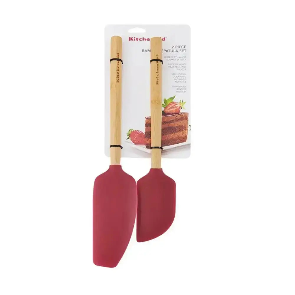 Two red spatulas with wooden handles on a white background, with packaging in the background.