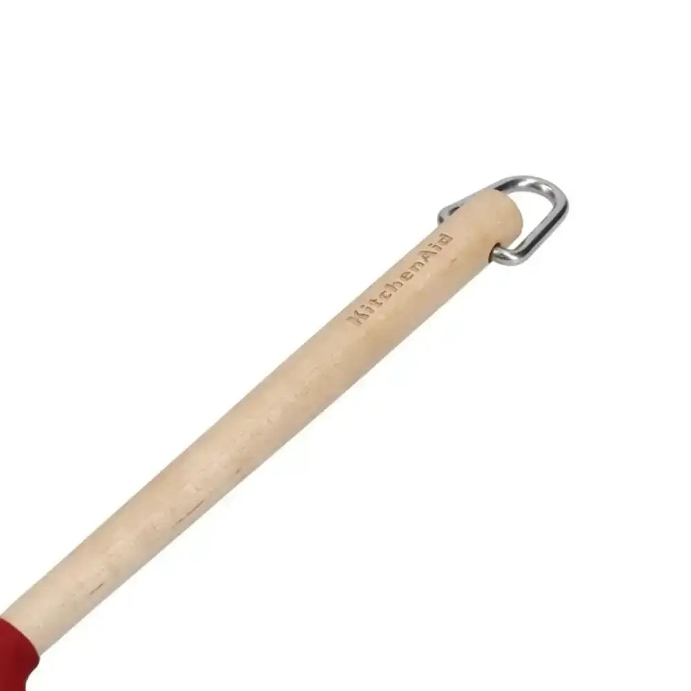 Wooden utensil with red end and metal handle on a white background