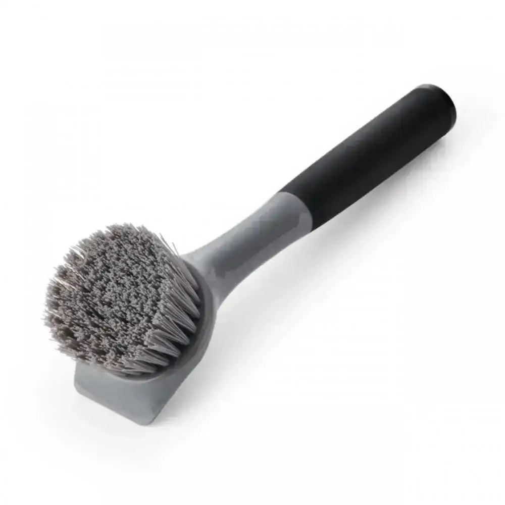 Cleaning brush with gray bristle head and black handle on a white background