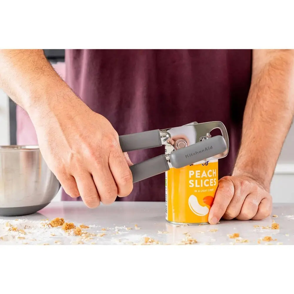 Stainless Steel bottle opener with black finish opening a can of peach slices