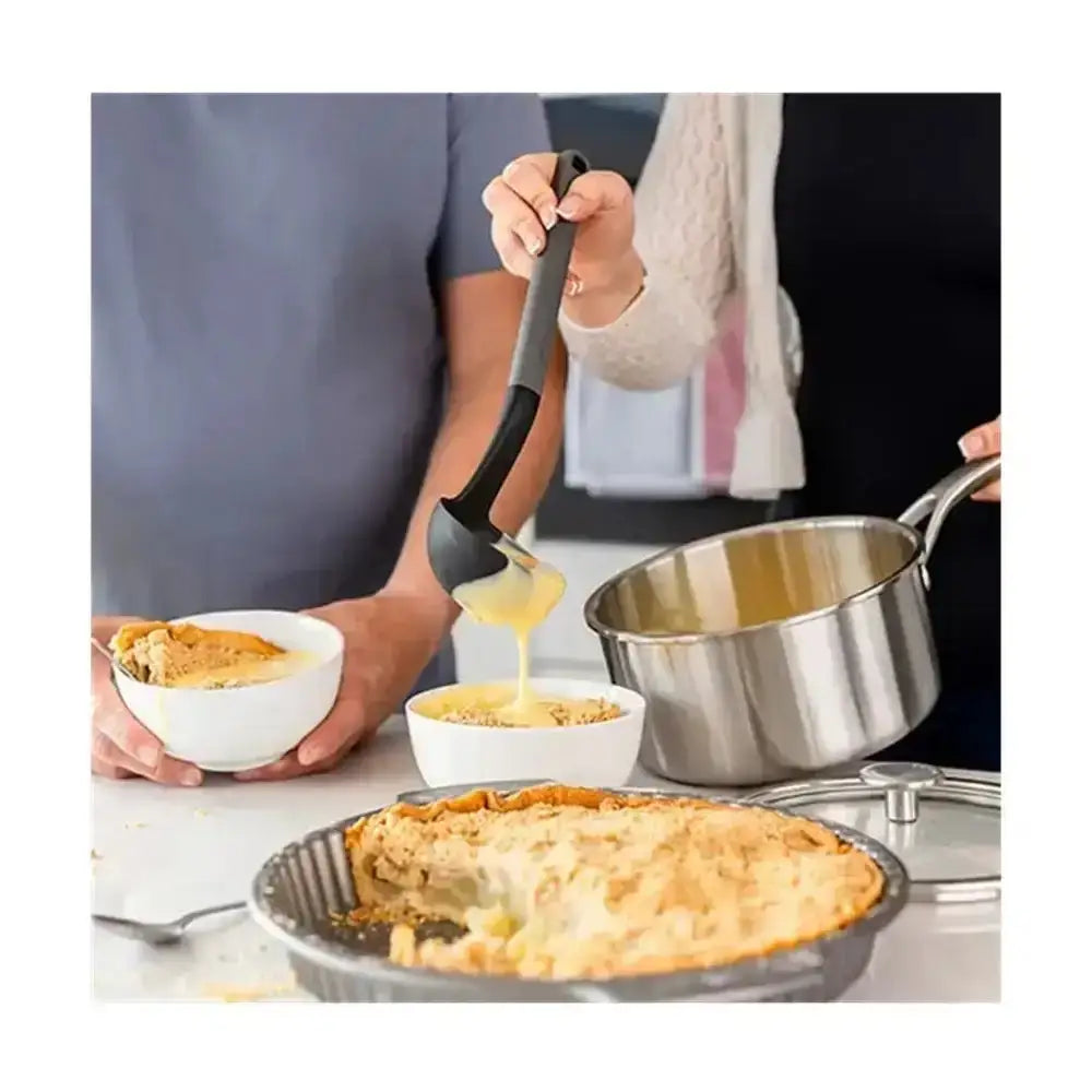 Person serving pie with a spatula, surrounded by kitchen items on a counter.