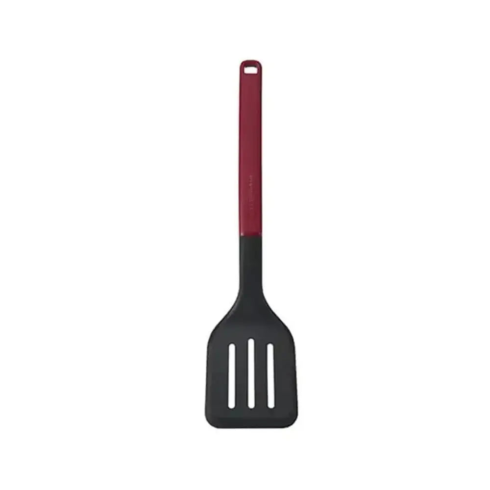 Black slotted spatula with red handle on a white background