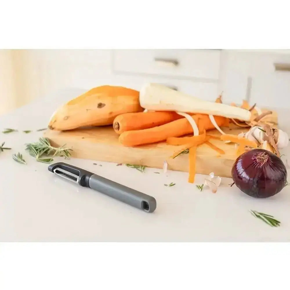 Vegetables on a cutting board with a peeler, on a light background