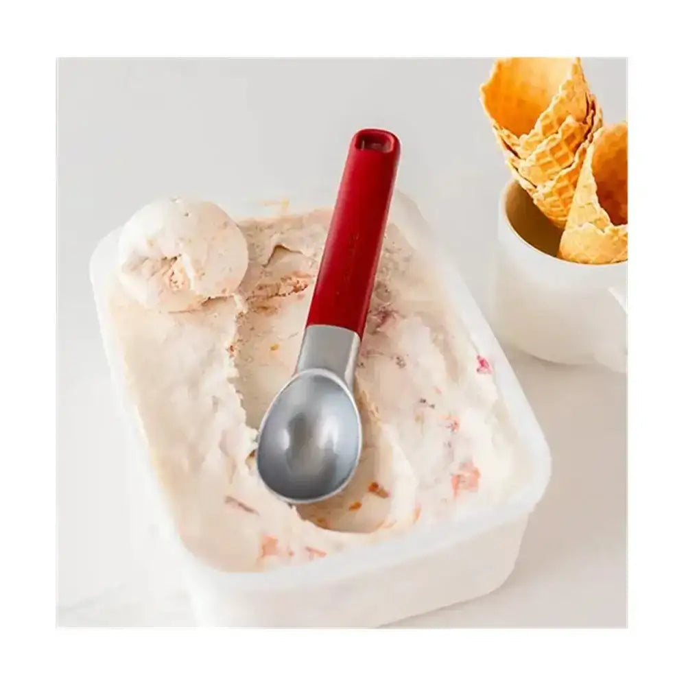 Container of ice cream with a red-handled silver scoop on a white background