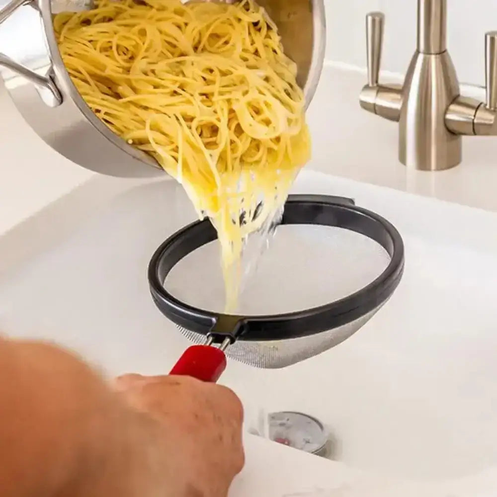 Person draining cooked spaghetti into a colander over a sink.