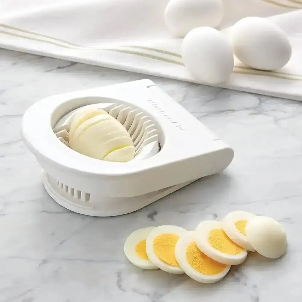 Egg slicer with sliced hard-boiled eggs on a marble surface
