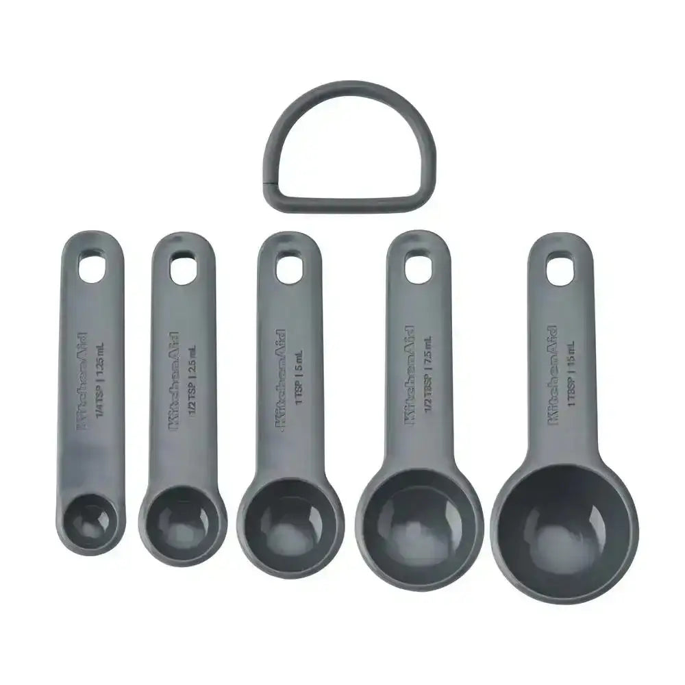 Set of six gray measuring spoons with a ring on a white background