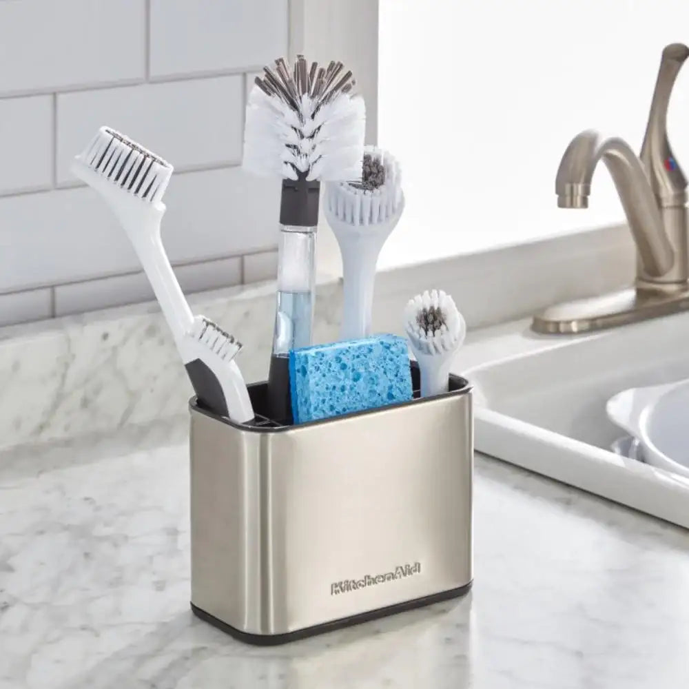 Kitchenaid utensil holder with cleaning brushes and sponge on a kitchen counter.