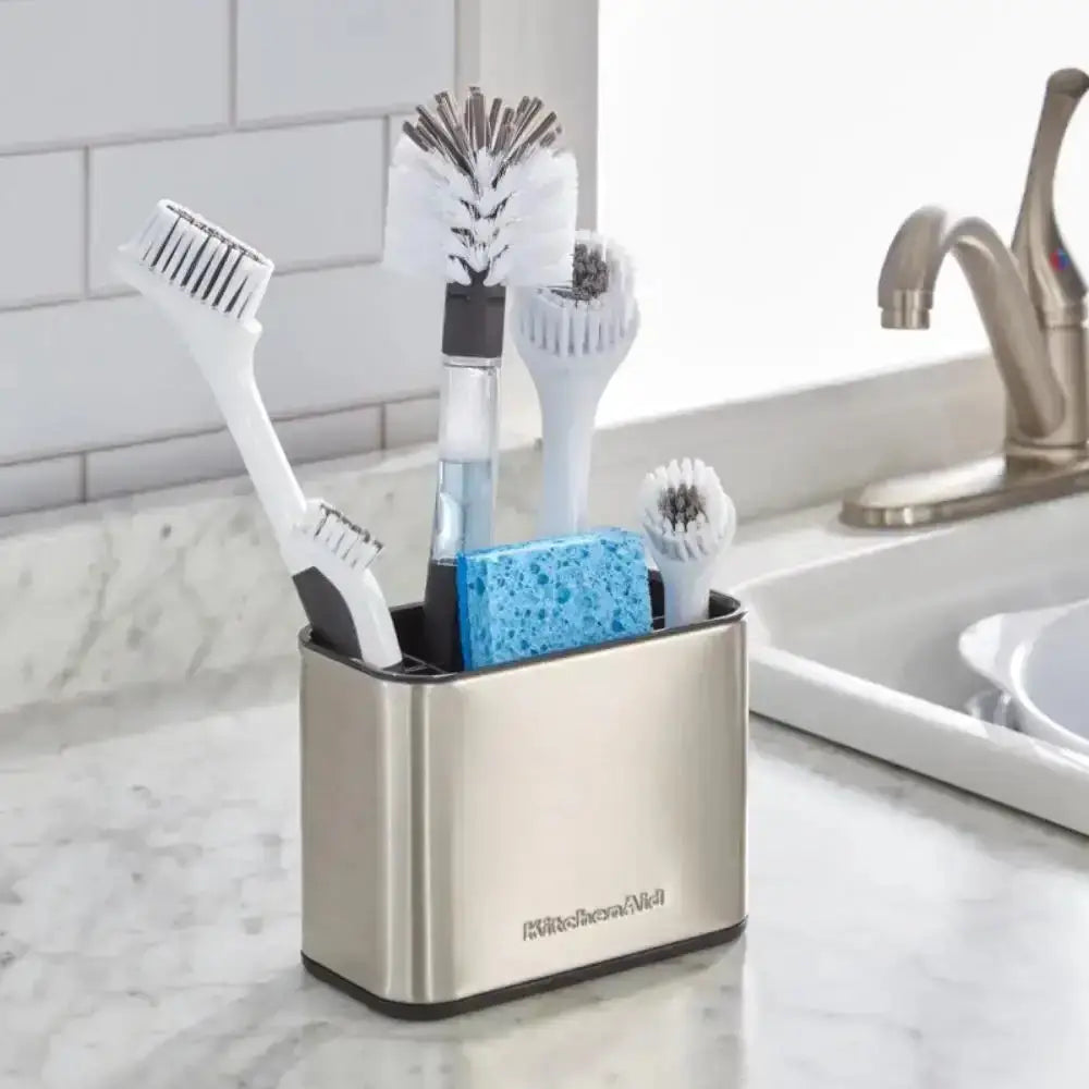 Kitchenaid utensil holder with cleaning brushes and sponge on a kitchen counter.