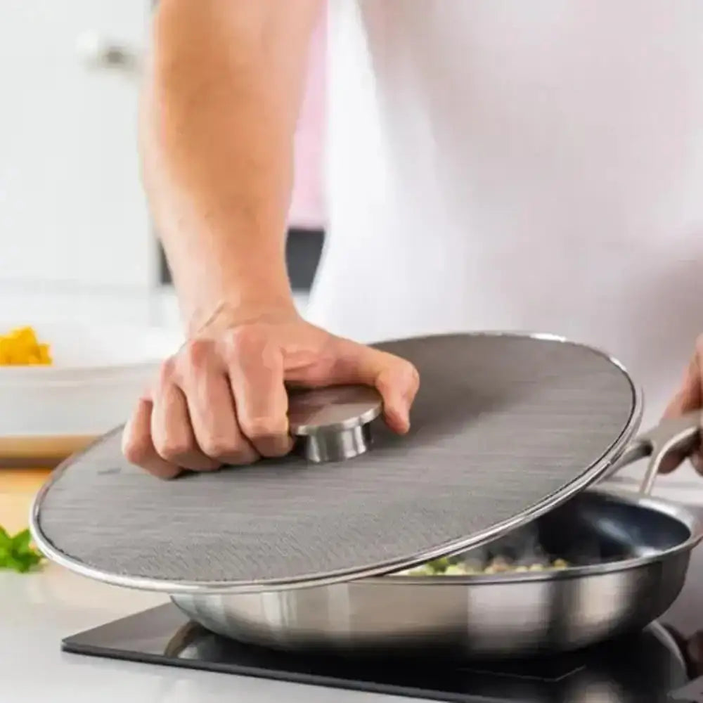 Person closing a metal lid on a frying pan with food inside