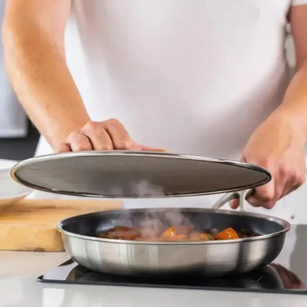 Person holding a lid over a steaming pan on a stove