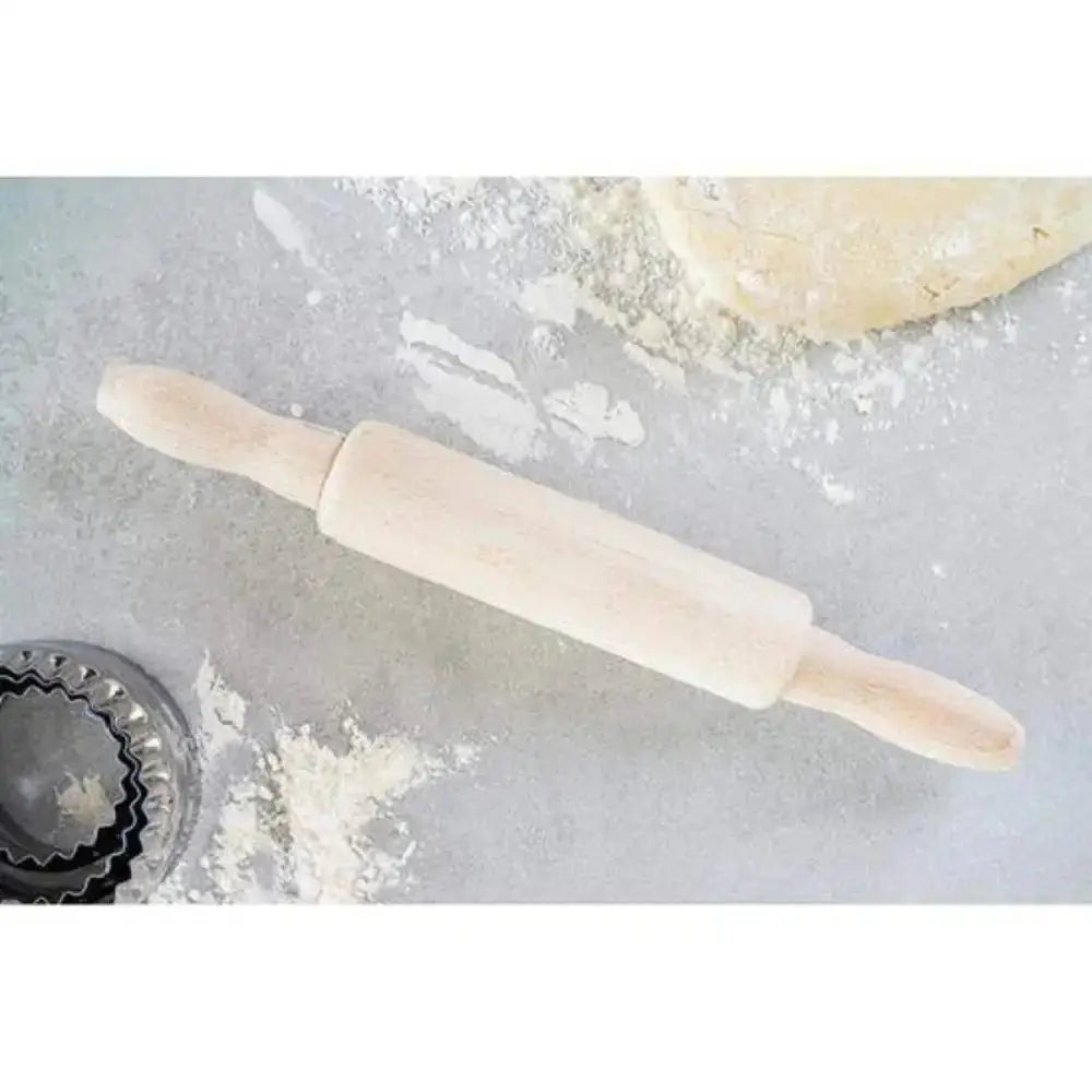Wooden rolling pin on a floured surface with dough and a metal cutter.