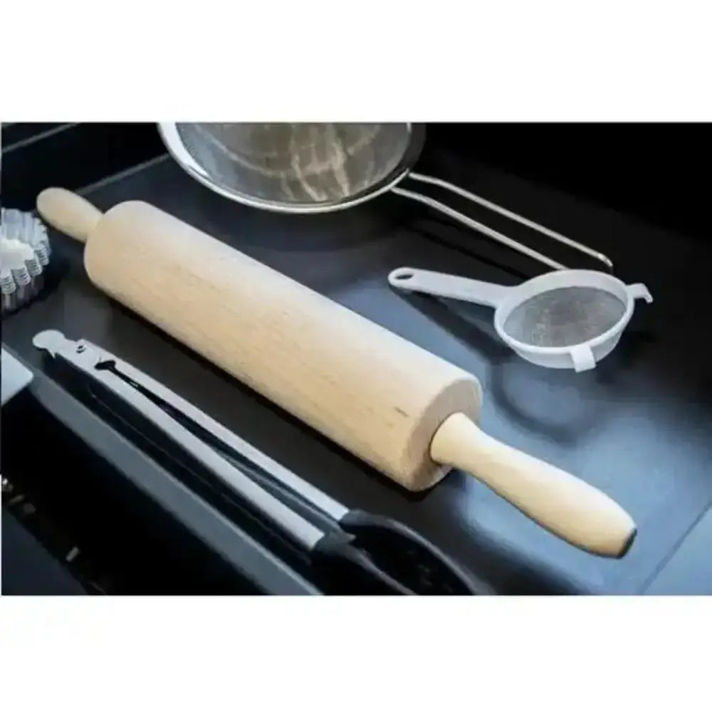 Wooden rolling pin on a black surface with kitchen utensils.