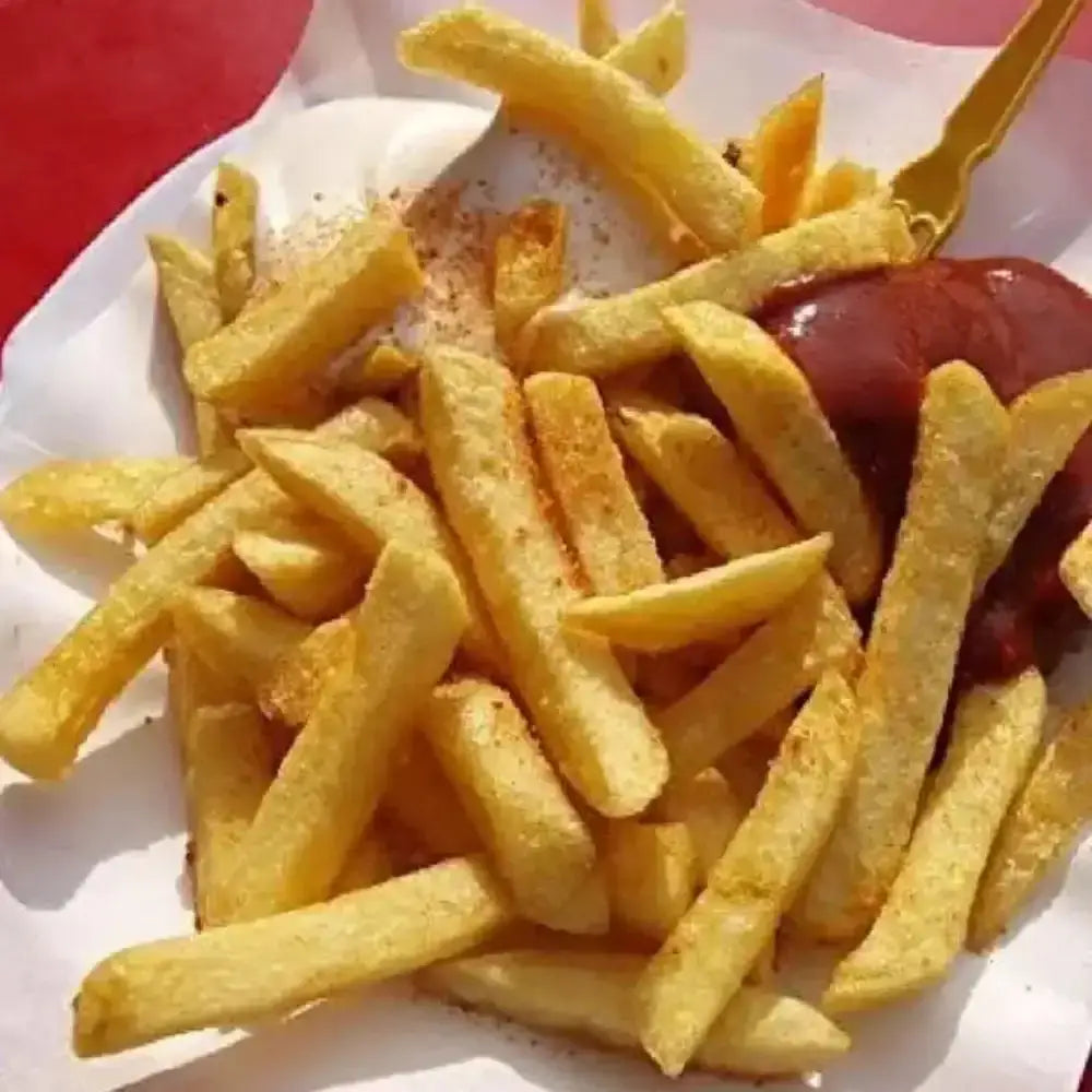 French fries with ketchup on a white plate against a red background