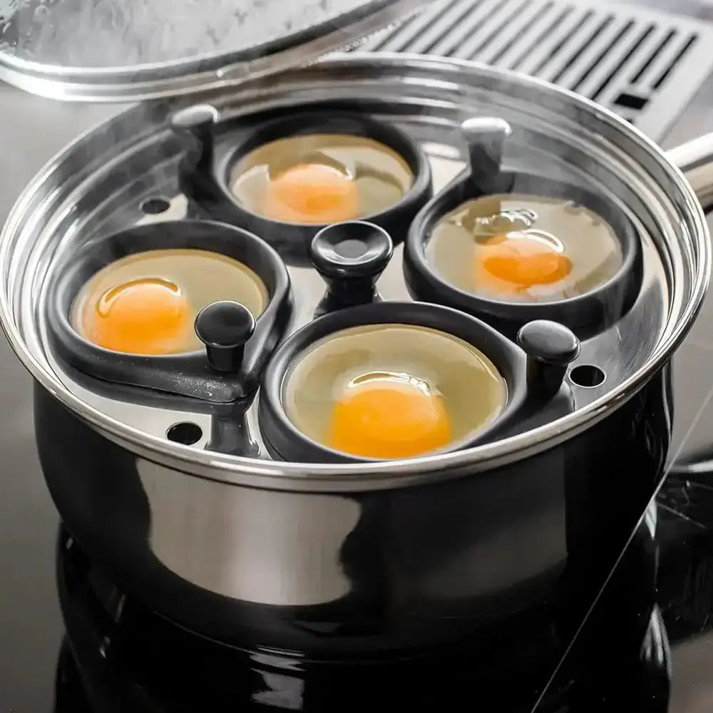 Egg cooker with four compartments containing eggs on a stove.