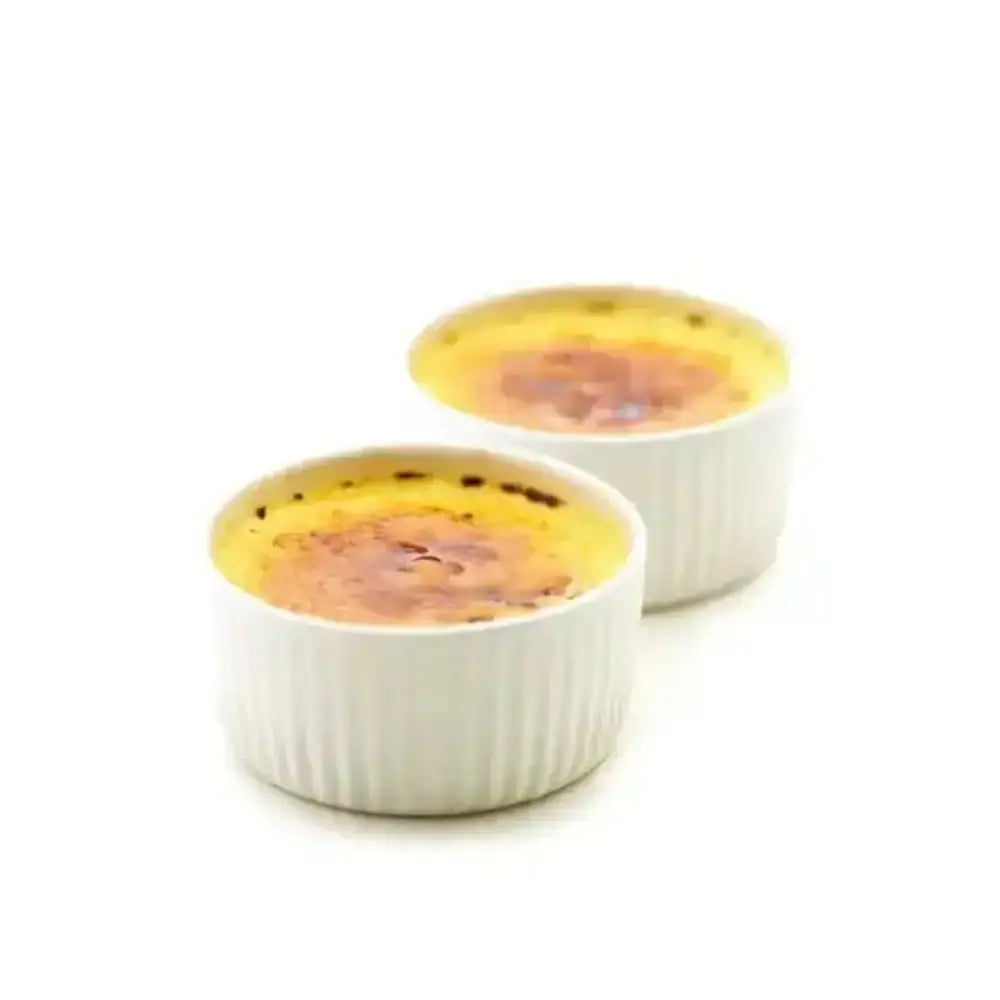 Two ramekins of crème bréleé on a white background