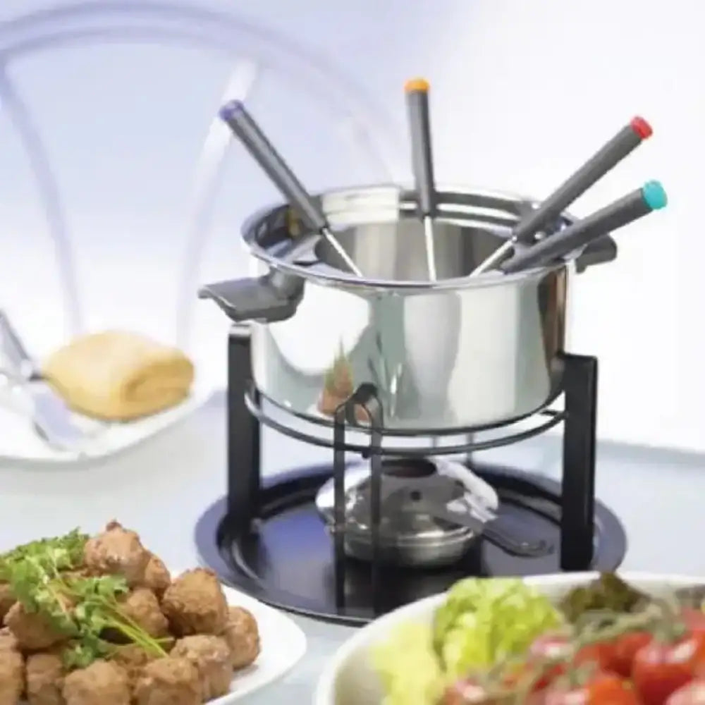 Stainless steel fondue pot with skewers on a stove, surrounded by food.