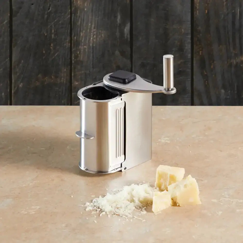 Manual cheese grater with grated cheese on a wooden surface