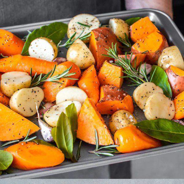 Roasted root vegetables with rosemary and garlic on a KitchenCraft non-stick metal oven tray 43cm