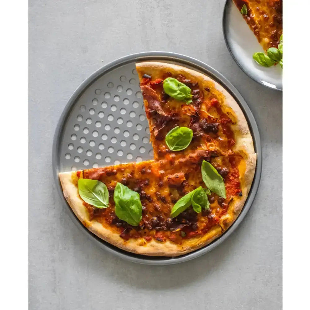 Pizza with basil leaves on a metal pizza peel with a slice removed.