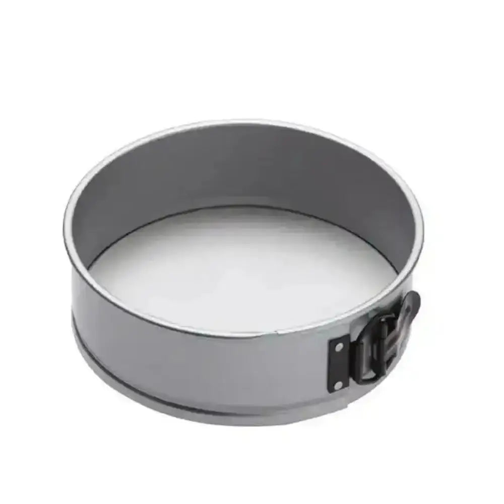 Metal springform pan with a white substance inside on a white background