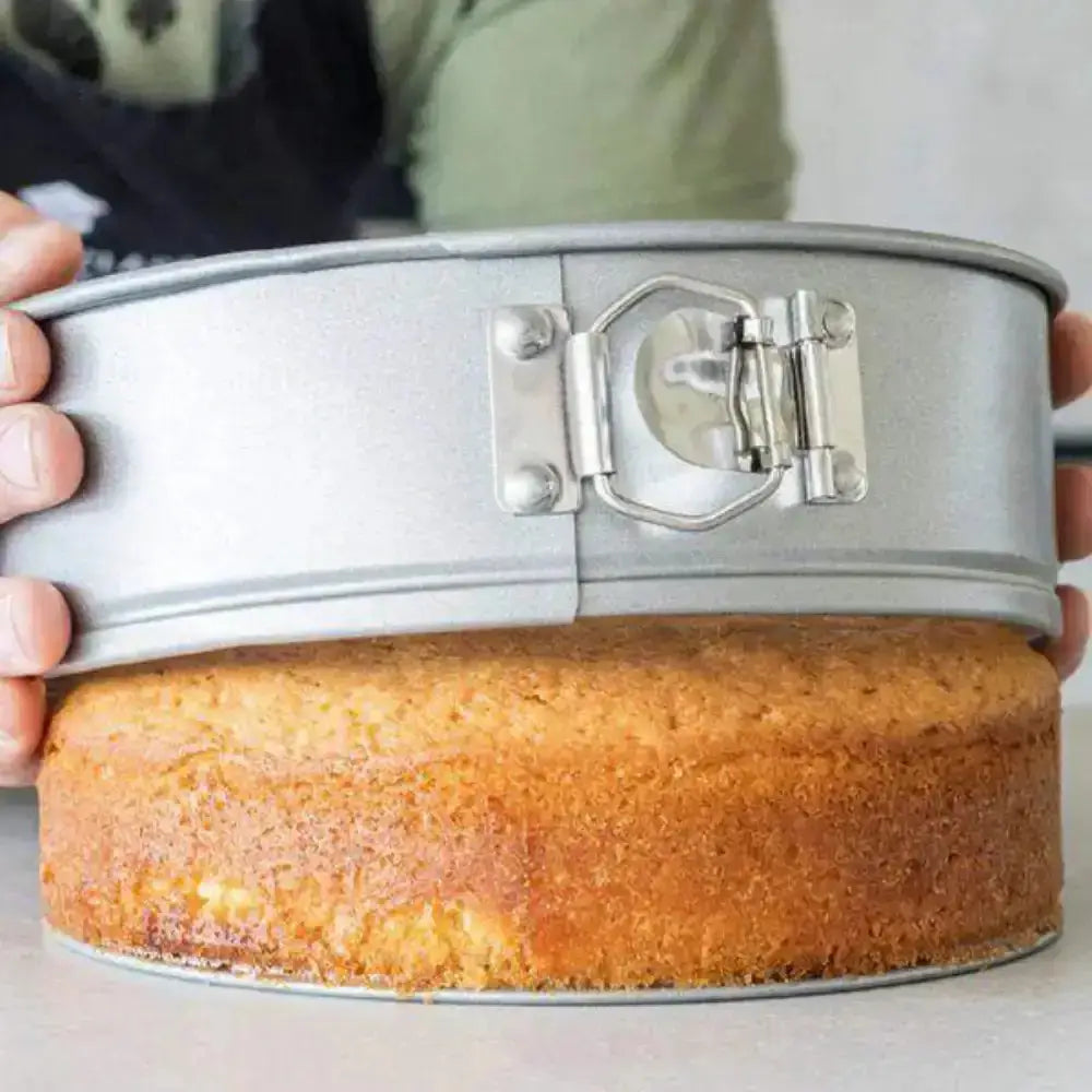 Person lifting a cake out of a springform pan