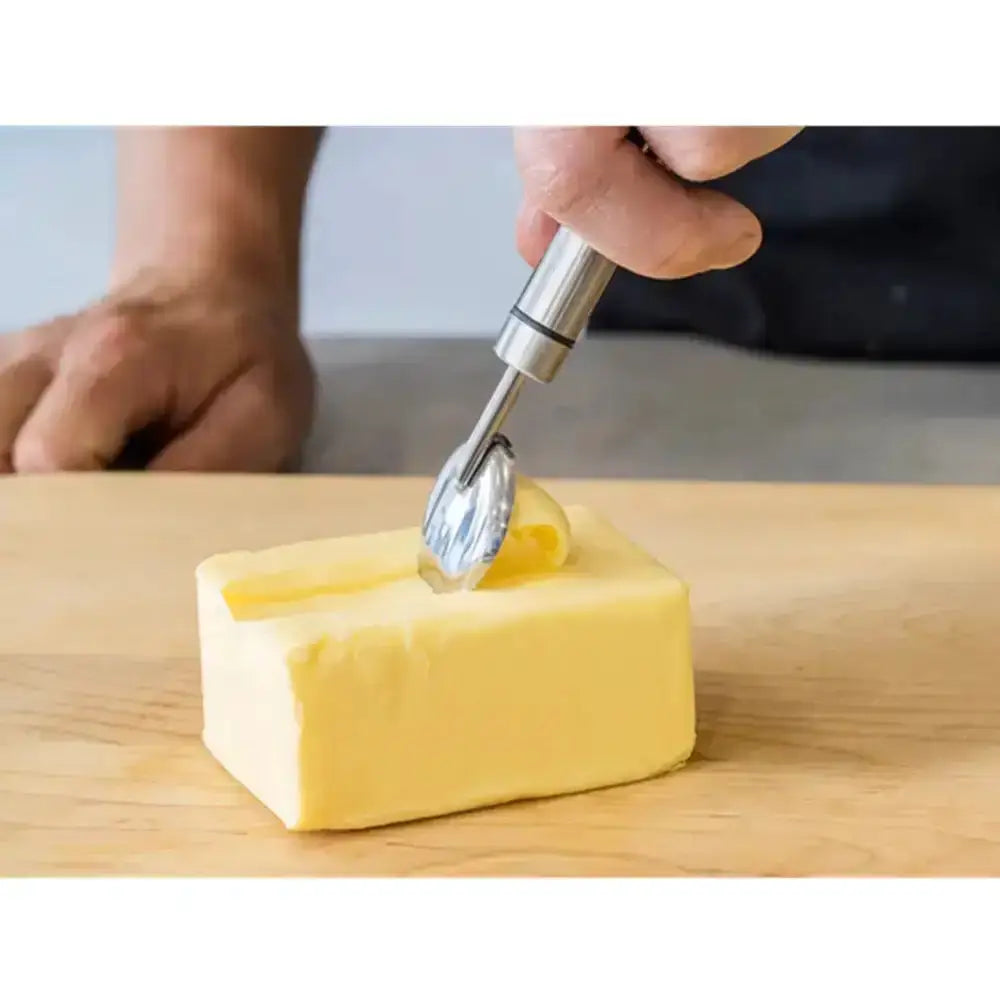 Butter being cut with a knife on a wooden surface