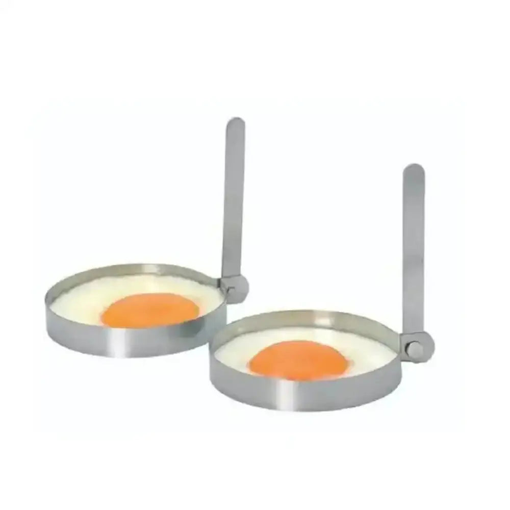 Two stainless steel egg rings with eggs inside on a white background