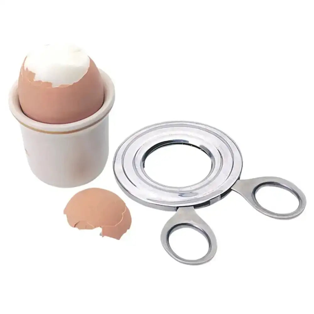 Egg cup with cracked shell and egg separator on a white background