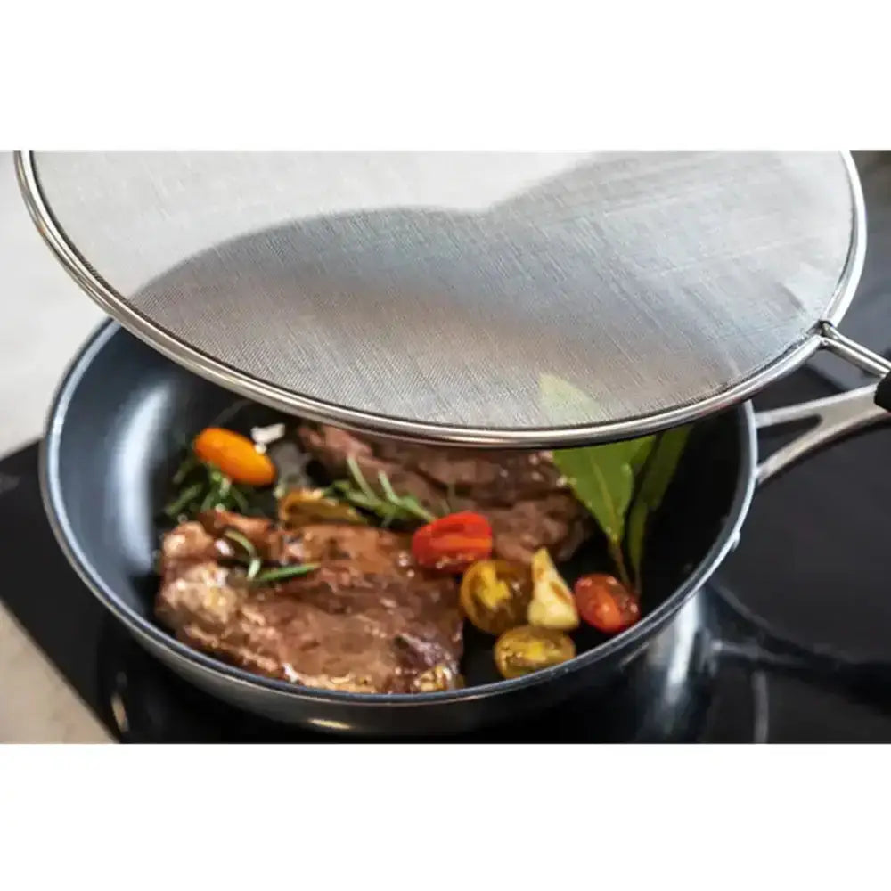 Steak and vegetables being cooked in a pan with a lid on top