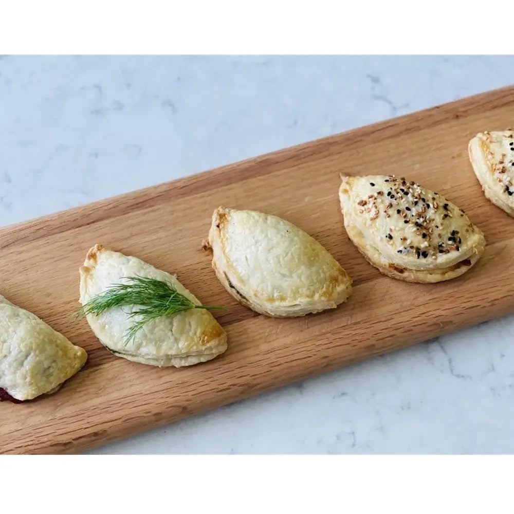 Small baked pastries on a wooden board with a marble background
