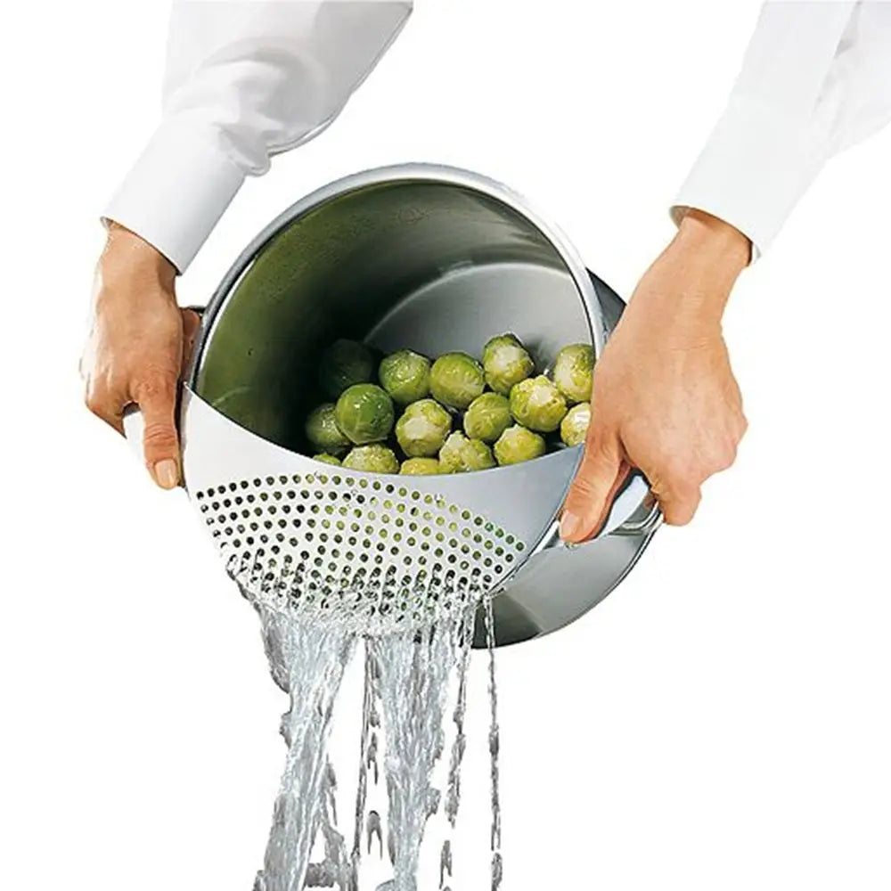 Person draining green vegetables with a metal colander.