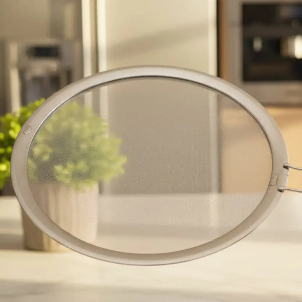 Metal splatter guard with handle on a white background