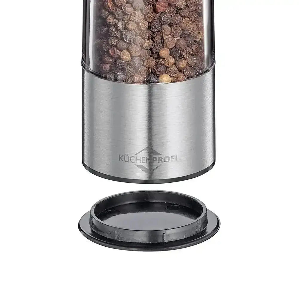 Stainless steel pepper grinder with black peppercorns on a white background
